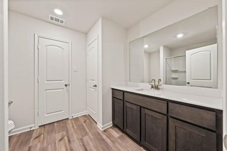 Bathroom with a shower, toilet, vanity, and hardwood / wood-style flooring