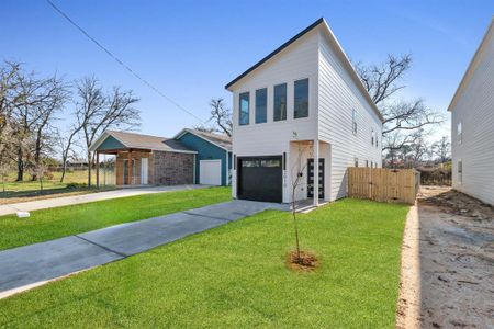 View of front of home with a garage and a front lawn