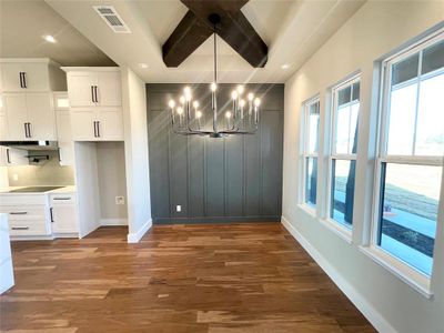 Dining room featuring a beam ceiling, wood floor and delightful accent wall