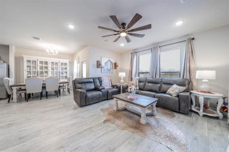 Living room featuring light hardwood / wood-style flooring and ceiling fan with notable chandelier