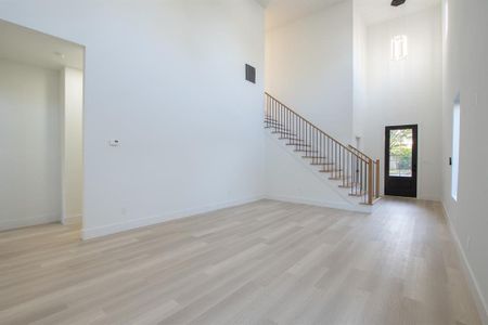 Entryway featuring light wood-type flooring and a towering ceiling