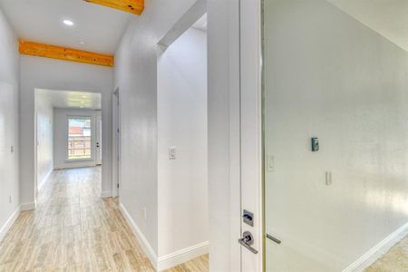 Corridor featuring light hardwood / wood-style floors and beamed ceiling