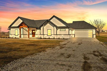 View of front of house with a garage and a lawn