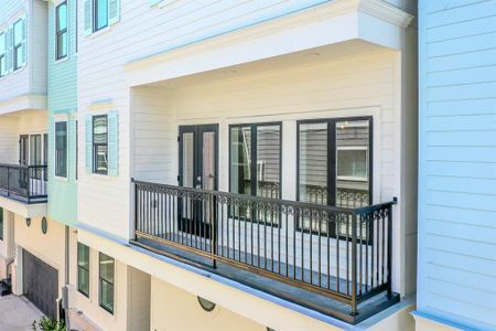 The property features a modern balcony with elegant black railings and large windows, offering a stylish and inviting outdoor space outside of the main living area.