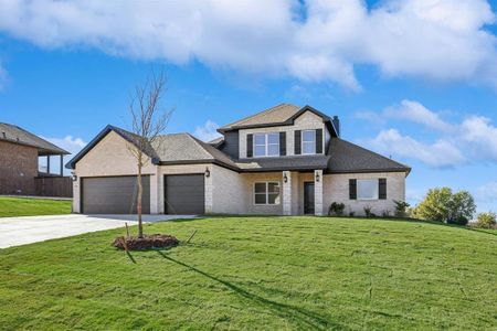 View of front of home with a garage and a front lawn