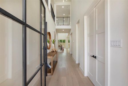 Corridor featuring a high ceiling and light hardwood / wood-style flooring