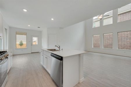 Kitchen featuring sink, light hardwood / wood-style flooring, stainless steel appliances, and white cabinets