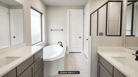 Bathroom with vanity, plenty of natural light, tile patterned floors, and tiled bath