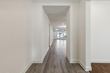 Hall with crown molding and dark hardwood / wood-style floors