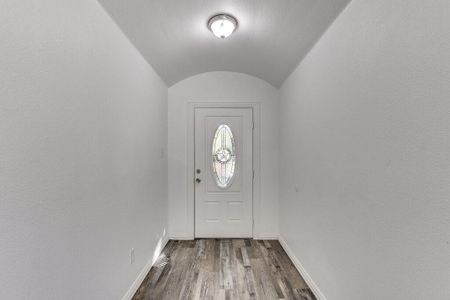 Entryway featuring vaulted ceiling and dark hardwood / wood-style floors