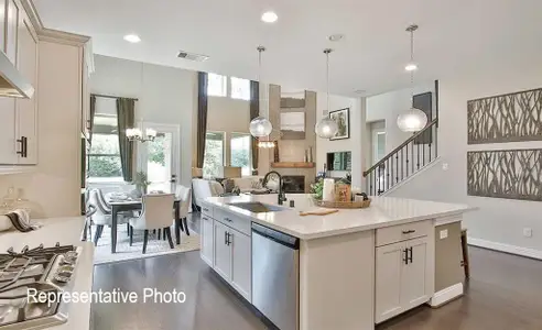 Kitchen featuring decorative light fixtures, appliances with stainless steel finishes, an island with sink, and dark hardwood / wood-style floors