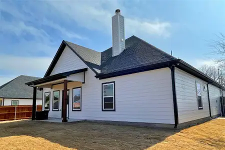 Back of house with a yard and a patio