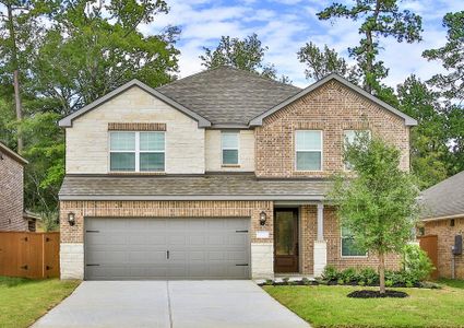 Two story home with brick and stone with front yard landscaping