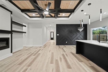 Unfurnished living room featuring sink, light wood-type flooring, ceiling fan, and wood ceiling