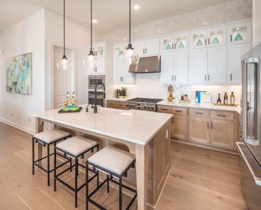 Kitchen featuring light countertops, appliances with stainless steel finishes, light wood-style floors, and under cabinet range hood