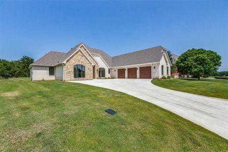 View of front of home with a garage and a front lawn