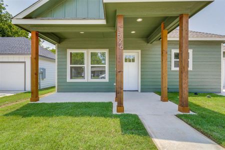 Property entrance featuring a garage and a yard