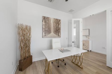 Home office with baseboards, light wood-style flooring, and a ceiling fan