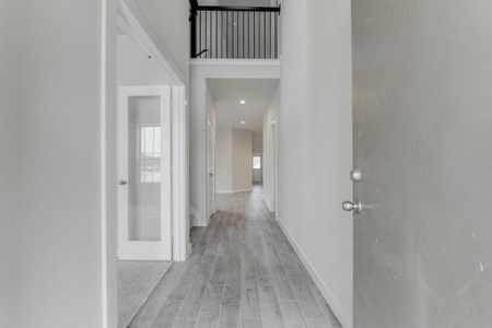 The majestic entryway allures with its high ceilings, embellished with sophisticated wood-look tile flooring and sleek oversized baseboards. Sample photo of completed home with similar floor plan. As-built interior colors and selections may vary.