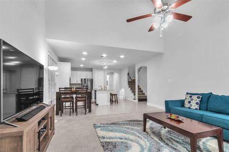 Living area with baseboards, arched walkways, a ceiling fan, stairway, and recessed lighting