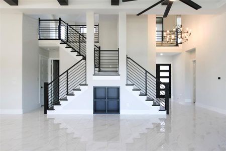 Staircase with a chandelier and a high ceiling