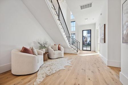 Step into the inviting embrace of this elegant sitting area nestled in the heart of the entry foyer, a distinctive feature of this stunning home.