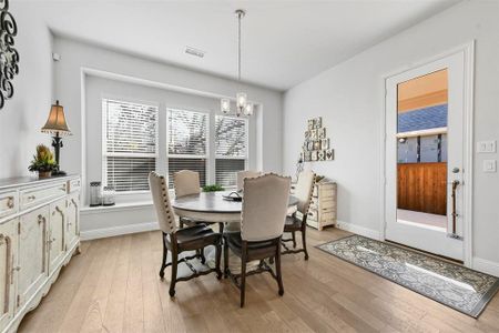 Dining space with an inviting chandelier and light hardwood / wood-style flooring