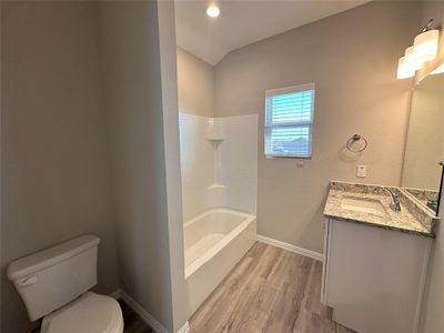 Full bathroom with vanity, toilet, tub / shower combination, and hardwood / wood-style flooring