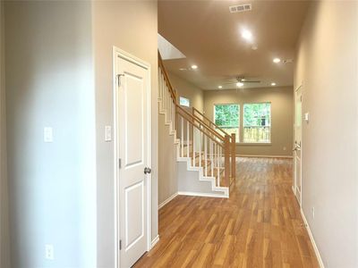 Corridor with light wood-type flooring, baseboards, recessed lighting, and stairs Corridor with light wood-type flooring, baseboards, recessed lighting, and stairs