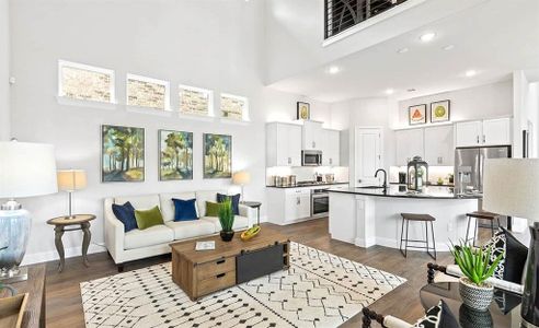 Living room with a high ceiling, hardwood / wood-style flooring, and sink