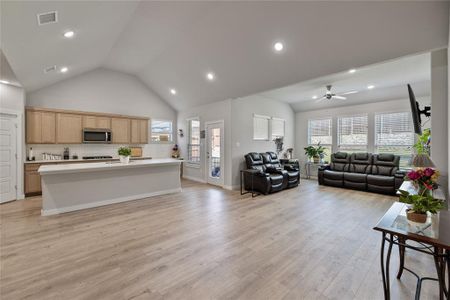 Living room with ceiling fan, light hardwood / wood-style flooring, and a healthy amount of sunlight