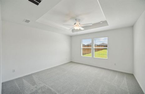 Elegant owner's suite with tray ceiling *real home pictured