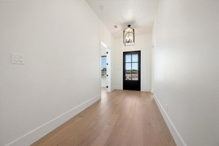 Doorway to outside featuring a chandelier and light hardwood / wood-style flooring