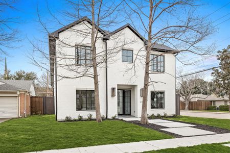 View of front of home with brick siding, a front yard, and fence