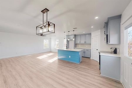 Kitchen featuring a center island with sink, light hardwood / wood-style floors, and a wealth of natural light