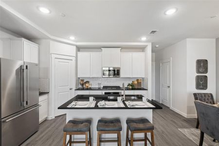 Kitchen with a kitchen island with sink, dark hardwood / wood-style flooring, and stainless steel appliances