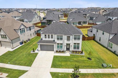 View of front of property featuring a garage, central AC, and a front yard