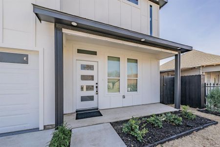 View of exterior entry featuring a garage and a porch