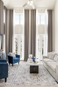 Living room featuring a towering ceiling, a wealth of natural light, and ceiling fan