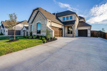 French country style house featuring a garage and a front yard