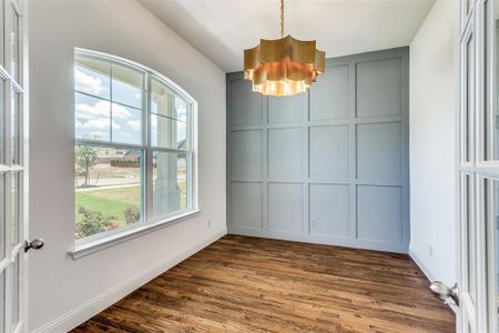 Empty room featuring plenty of natural light, dark hardwood / wood-style floors, and an inviting chandelier