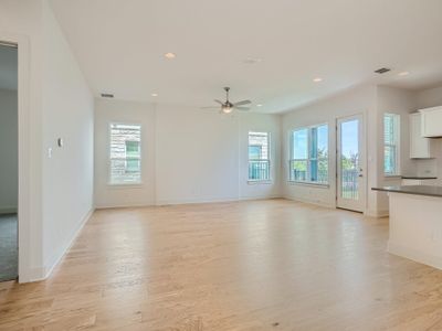 Unfurnished living room featuring ceiling fan and light hardwood / wood-style flooring