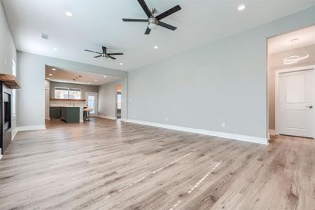 Unfurnished living room with light hardwood / wood-style flooring and ceiling fan