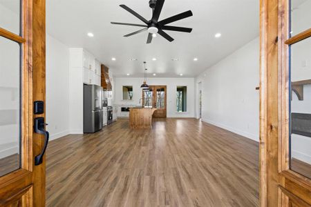 Living room with dark hardwood / wood-style flooring and ceiling fan