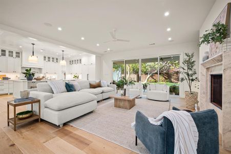 Living room with light hardwood / wood-style floors, a fireplace, sink, and ceiling fan