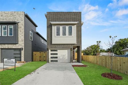 View of front of home with a front lawn and a garage