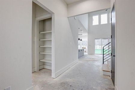 Corridor featuring built in features and a high ceiling