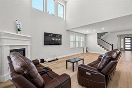 Living room featuring a high ceiling and light hardwood / wood-style floors