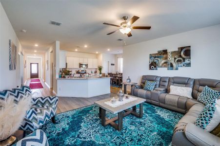 Living room with light wood-type flooring and ceiling fan