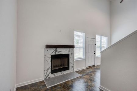 Unfurnished living room with a fireplace and dark tile patterned flooring